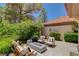Cozy outdoor patio with a stylish fire pit and comfortable seating surrounded by lush greenery at 7988 Pinnacle Peak Ave, Las Vegas, NV 89113