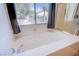 Relaxing bathroom featuring a large soaking tub and natural light from the window at 8029 Flambeau St, Las Vegas, NV 89131