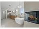 Stunning bathroom featuring a soaking tub, fireplace, shower, double vanity, and modern chandelier at 8032 Deep Stone Ave, Las Vegas, NV 89149