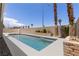 An inviting swimming pool with a spa, surrounded by desert landscaping and tall palm trees at 8032 Deep Stone Ave, Las Vegas, NV 89149