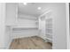 Spacious walk-in closet with custom shelves, rods, and ample storage, complemented by stylish wood-look flooring at 8032 Deep Stone Ave, Las Vegas, NV 89149
