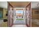 Inviting balcony with tile flooring, seating and views of the neighborhood through the open french doors at 8223 Saddleback Ledge Ave, Las Vegas, NV 89147