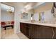 Bathroom boasts double sinks with dark wood cabinetry and an open door to the living room at 8223 Saddleback Ledge Ave, Las Vegas, NV 89147
