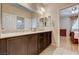 Bathroom boasts double sinks with dark wood cabinetry and an open door to the bedroom at 8223 Saddleback Ledge Ave, Las Vegas, NV 89147