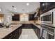 A kitchen featuring dark cabinetry, granite countertops, stainless steel appliances, and a center island at 8223 Saddleback Ledge Ave, Las Vegas, NV 89147