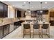 Stylish kitchen featuring dark cabinetry, stainless steel appliances, and a kitchen island with bar stools at 8223 Saddleback Ledge Ave, Las Vegas, NV 89147