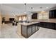 A kitchen with a center island, open concept to the living room, granite countertops, and dark cabinetry at 8223 Saddleback Ledge Ave, Las Vegas, NV 89147