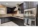 A kitchen boasting granite countertops, stainless steel appliances, dark cabinetry, and tile flooring at 8223 Saddleback Ledge Ave, Las Vegas, NV 89147