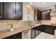 A kitchen featuring granite countertops, stainless steel appliances, tile backsplash, and dark cabinetry at 8223 Saddleback Ledge Ave, Las Vegas, NV 89147