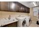 Laundry room featuring a sink, countertop, cabinets, washer, dryer, and overhead lighting at 8223 Saddleback Ledge Ave, Las Vegas, NV 89147