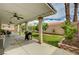 Covered patio with ceiling fans, grill, and landscaped backyard, perfect for outdoor entertaining at 8223 Saddleback Ledge Ave, Las Vegas, NV 89147