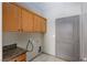 Functional laundry room with upper cabinets, tile flooring and access to the backyard at 854 Santa Maria Way, Mesquite, NV 89027