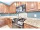 Updated kitchen with wood cabinetry, granite countertops, and stainless steel appliances at 8560 Osmerea Ct, Las Vegas, NV 89149