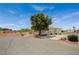 Quaint single-story home featuring a mature tree, desert landscaping, and a circular driveway leading to the arched front gate at 9025 S Tenaya Way, Las Vegas, NV 89113