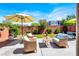 Serene backyard with a cozy seating area under an umbrella, lush greenery, and well-maintained landscaping at 9236 Keystone Ridge Ave, Las Vegas, NV 89148