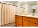 Bathroom showcasing a double vanity with wood cabinets and a shower with a curtain at 9236 Keystone Ridge Ave, Las Vegas, NV 89148