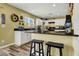 Bright kitchen features white cabinets, black appliances, and a breakfast bar with stylish stools at 9236 Keystone Ridge Ave, Las Vegas, NV 89148