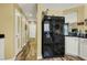 Kitchen area with black refrigerator and wood-look flooring leading into a hallway at 9236 Keystone Ridge Ave, Las Vegas, NV 89148