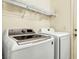 Bright laundry room featuring modern washer and dryer with wire shelving above at 9236 Keystone Ridge Ave, Las Vegas, NV 89148