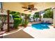 Covered outdoor patio overlooking a private pool and lush tropical backyard at 9413 Cedar Heights Ave, Las Vegas, NV 89134