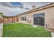 Backyard featuring a covered patio, artificial turf, and a sliding door to the home at 9622 Emeraude Ave, Las Vegas, NV 89147