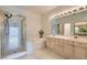 Bathroom featuring a glass shower, soaking tub, double sink vanity, and a large mirror at 9622 Emeraude Ave, Las Vegas, NV 89147