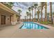 Community pool with palm trees and a covered lounging area perfect for relaxing and soaking up the sun at 9622 Emeraude Ave, Las Vegas, NV 89147