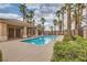 A shimmering community pool surrounded by palms, a lounging area, and lush greenery for community residents at 9622 Emeraude Ave, Las Vegas, NV 89147