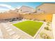 Expansive backyard featuring artificial turf, desert landscaping, and a custom fire pit area at 9934 Iron Creek Ave, Las Vegas, NV 89178