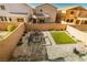 Backyard oasis featuring synthetic lawn, paver patio, and fire pit seating area at 9934 Iron Creek Ave, Las Vegas, NV 89178