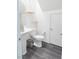 Clean and simple half-bathroom with pedestal sink and decorative floating shelves at 9934 Iron Creek Ave, Las Vegas, NV 89178