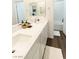 Bathroom with dual sinks, white countertops and cabinets, and neutral-colored wood floors at 9934 Iron Creek Ave, Las Vegas, NV 89178
