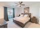 Bright bedroom featuring a large bed, ceiling fan, balcony access and carpeted floors at 9934 Iron Creek Ave, Las Vegas, NV 89178