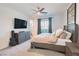 Bedroom with neutral tones, TV, dresser, and bed with light-colored bedding and ceiling fan at 9934 Iron Creek Ave, Las Vegas, NV 89178