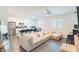 Bright and airy living room with hardwood floors, ceiling fan, and comfortable sectional sofa at 9934 Iron Creek Ave, Las Vegas, NV 89178