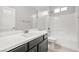 Bright bathroom with white vanity, framed mirror, and tub with white tile surround at 1129 Via Della Curia, Henderson, NV 89011