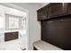 Charming laundry area with built-in cabinets, sink, bench and bead-board detail at 1129 Via Della Curia, Henderson, NV 89011