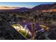 Aerial night view of backyard featuring a pool, hot tub, and well-manicured lawn and mountain view at 1144 Calico Ridge Dr, Henderson, NV 89011