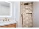 Contemporary bathroom with a rainfall showerhead, a unique patterned wall, and a lighted mirror at 1144 Calico Ridge Dr, Henderson, NV 89011