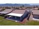 Aerial view of backyard featuring covered patio with ceiling fans and well-maintained lawn at 1195 Golf Club Dr, Laughlin, NV 89029