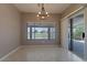 Bright dining area with chandelier, large windows, and sliding glass doors to the patio at 1195 Golf Club Dr, Laughlin, NV 89029