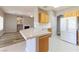Bright kitchen featuring a breakfast bar, white appliances, and wooden cabinetry with adjacent living room at 1195 Golf Club Dr, Laughlin, NV 89029