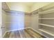 Spacious walk-in closet with ample shelving and rod space and wood-look vinyl flooring at 1195 Golf Club Dr, Laughlin, NV 89029