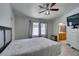 Comfortable bedroom featuring wood-look tile flooring, ceiling fan, and an attached bathroom at 1905 Eskam St, Las Vegas, NV 89156