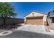 A single-car garage with a neutral tan door and trim matches the home's exterior, complemented by a lengthy driveway and mature tree at 1905 Eskam St, Las Vegas, NV 89156