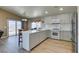 Stylish kitchen features white cabinets, bar seating, stainless steel appliances, quartz countertops, and wood-look floors with backyard access at 1905 Eskam St, Las Vegas, NV 89156