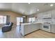 Spacious kitchen with modern white cabinets, quartz countertops, stainless steel appliances, and wood-look flooring overlooking living room at 1905 Eskam St, Las Vegas, NV 89156