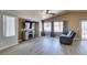 Open living room featuring a fireplace, large windows, vaulted ceiling, wood floors, and a loveseat at 1905 Eskam St, Las Vegas, NV 89156