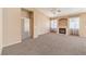 Carpeted living room with a fireplace, large windows, and an open doorway to the bedrooms at 201 Teller St, Henderson, NV 89074