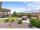 Private backyard with stone-lined garden beds, rock landscaping, a fire pit, and mountain views at 2207 Valdina St, Henderson, NV 89044